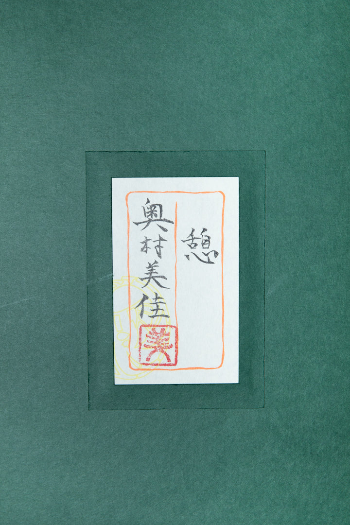 alt="Back of the painting 'Ikoi' with the title and artist seal of Mika Okumura"
