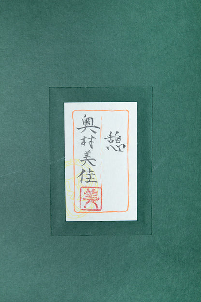 alt="Back of the painting 'Ikoi' with the title and artist seal of Mika Okumura"
