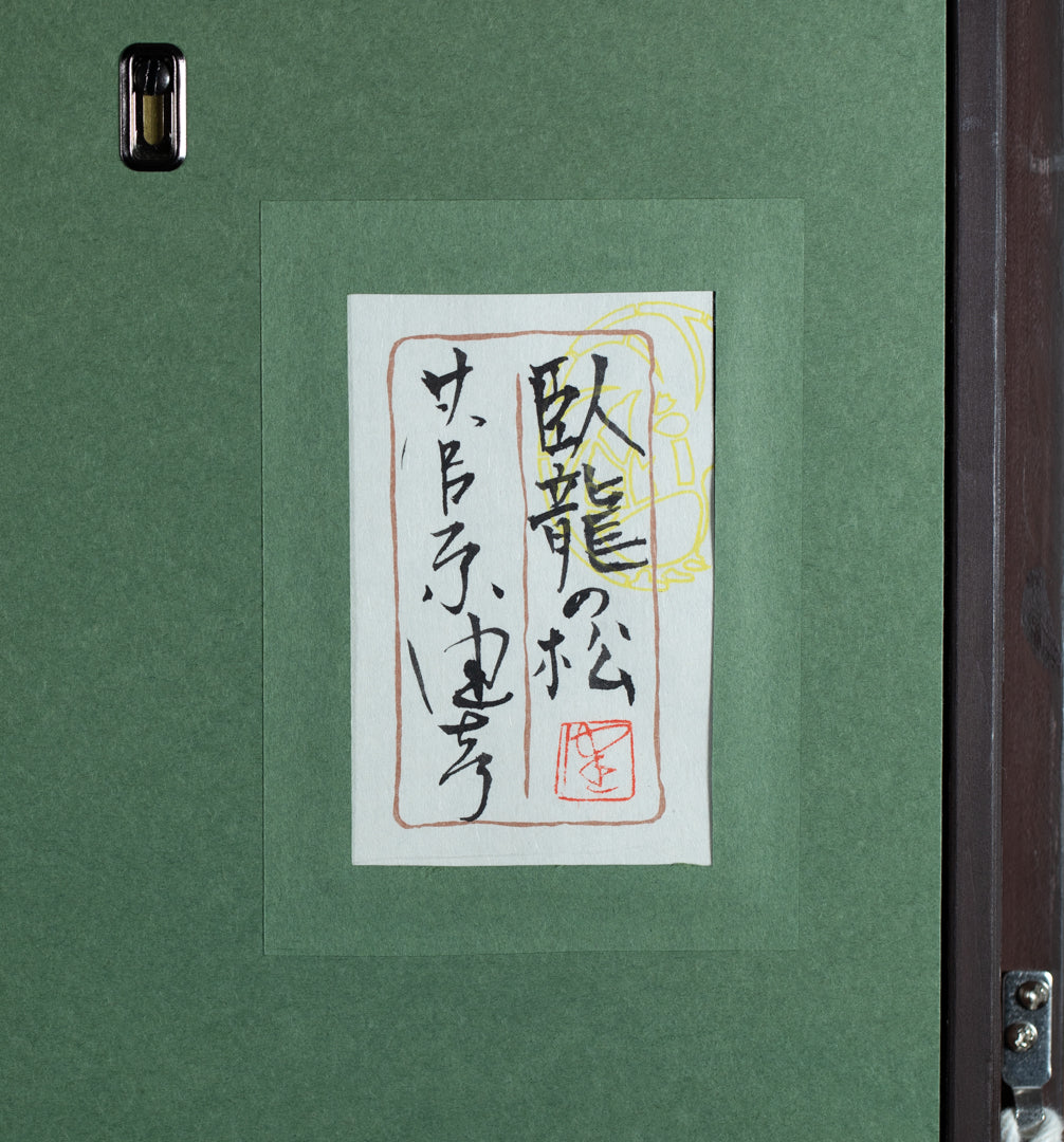 alt="Back of the painting 'The Reclining Dragon Pine' with the title and artist seal of Takehiko Sugawara"
